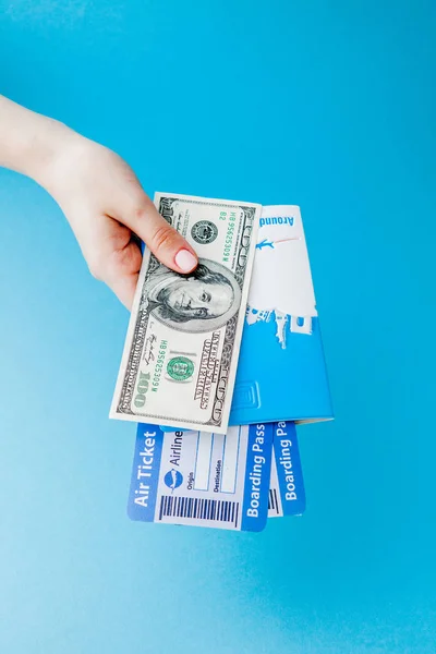 Paspoort, dollars en vliegticket in Woman hand op een blauwe backgro — Stockfoto