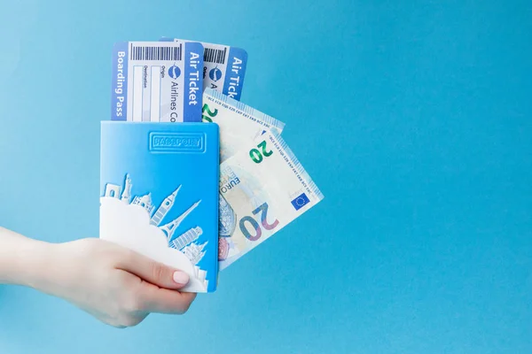 Pas, euro a letenku v ženské ruce na modrém pozadí — Stock fotografie