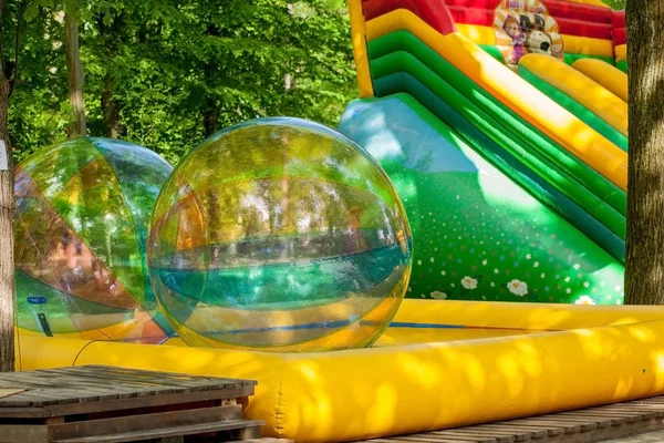 Aqua zorbing. Colorful water walking balls. Water activity for kids. Children playing together and having fun inside large inflatable sphere in a pool — Stock Photo, Image