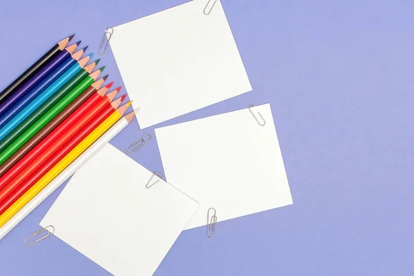 Hoja en blanco de papeles y lápices de color sobre fondo violeta para Proyectos y Anuncios, espacio de copia — Foto de Stock