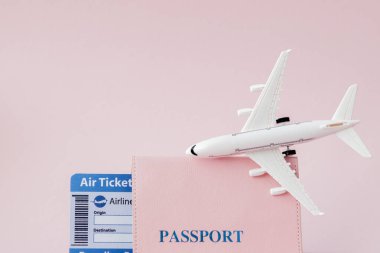 Pembe arka planda pasaport, uçak ve uçak bileti. Seyahat conc