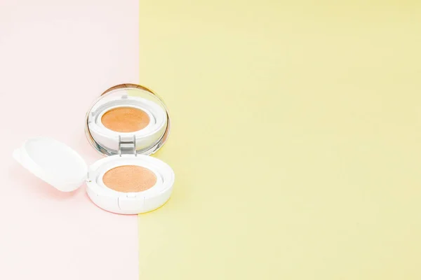 Make up produtos derramando em um backgro amarelo e rosa brilhante — Fotografia de Stock