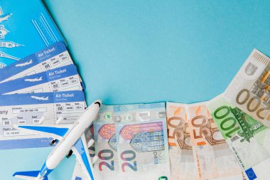 Pasaport, dolar ve Euro, uçak ve hava bileti mavi bir arka üzerinde
