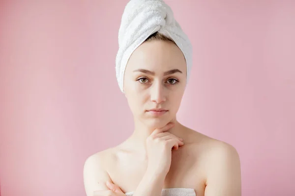 Wanita muda yang cantik setelah mandi dengan handuk di latar belakang merah muda — Stok Foto