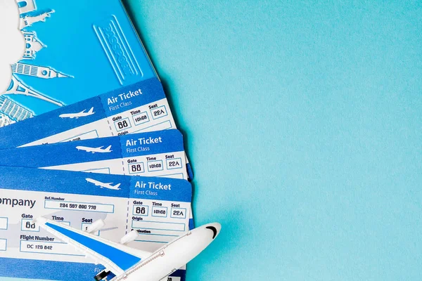 Pasaporte, avión y billete de avión sobre fondo azul. Viaje c — Foto de Stock