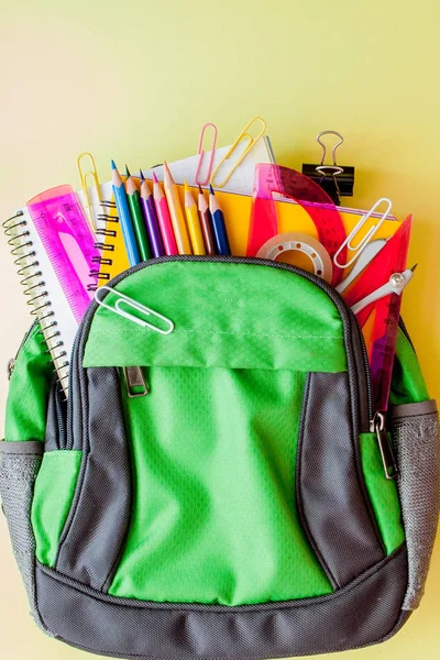 Flat lay composition with backpack and school stationery on yell — Stock Photo, Image