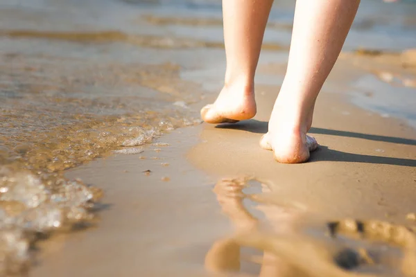 在沙滩上行走的女人在沙滩上留下了脚印。海滩 — 图库照片
