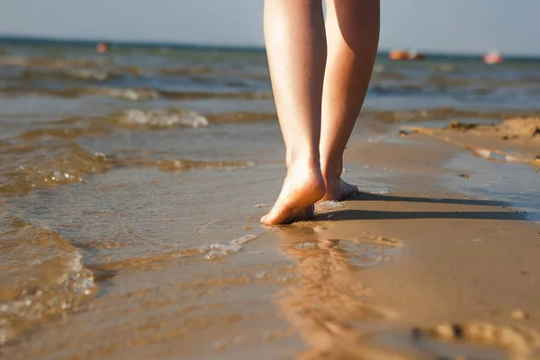 Женщина ходит по песчаному пляжу, оставляя следы на песке. пляж — стоковое фото