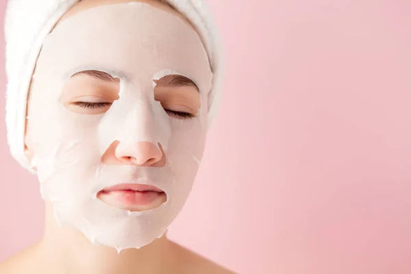 Wanita muda yang cantik menerapkan masker jaringan kosmetik pada sebuah fa — Stok Foto