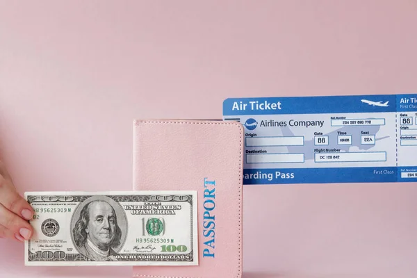 Passaporte, dólares e bilhete de avião na mão mulher em um backgro rosa — Fotografia de Stock