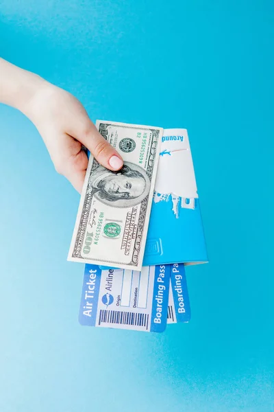 Paspoort, dollars en vliegticket in Woman hand op een blauwe achtergrond. Reis concept, kopieerruimte — Stockfoto