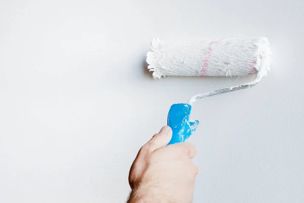 Woman hand holding a paint roller isolated on a white background — Stock Photo, Image