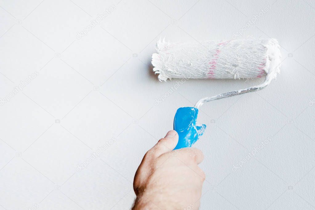 Woman hand holding a paint roller isolated on a white background