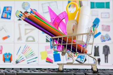 Klavyede okul araçlarıyla dolu alışveriş sepeti, online alışveriş