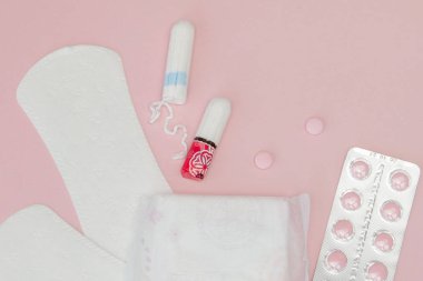 Hijyenik pedler, tamponlar ve pembe arka plan üzerinde haplar. Kadın cr