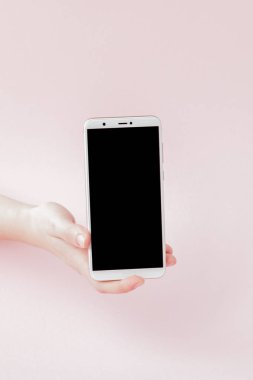 Pembe arka planda bir kadının elinde modern cep telefonu