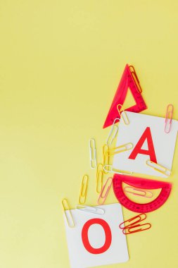 Metin alanı ile okul konseptine geri dönün. Üst görünüm. Boşluk Kopyala. Okul ofisi malzemeleri. Renkli Kırtasiye ile yaratıcı masa. Renkli kağıt klip. Sarı arka planda okul malzemeleri. Ofis Masası