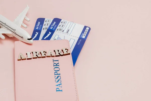 Inscriptie "vliegtickets", vliegtuig, lucht ticket en geld op een roze — Stockfoto