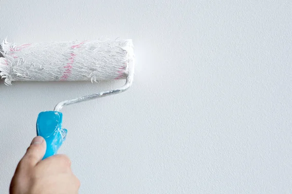 Woman hand holding a paint roller isolated on a white background — Stock Photo, Image