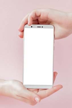 Pembe arka planda bir kadının elinde modern cep telefonu