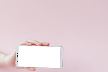 Pembe arka planda bir kadının elinde modern cep telefonu