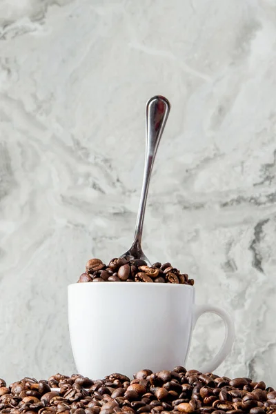 Mermer arka planda fincan ve kahve çekirdekleri siyah kahve. En iyi v