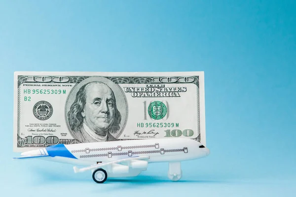 Avião e dólares num fundo azul. Conceito de viagem, cópia — Fotografia de Stock