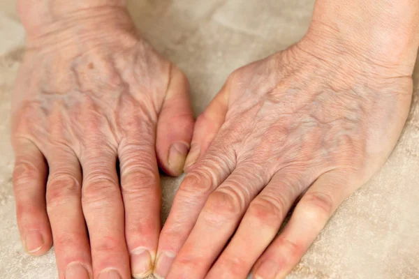 De handen van een vrouw op een wmarble achtergrond, plaats voor tekst — Stockfoto