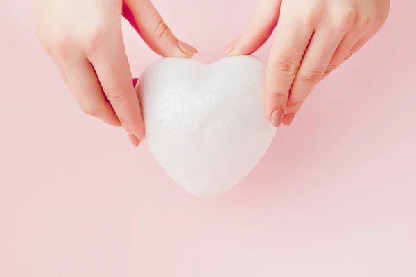Bianco vuoto amore cuore in mani su sfondo rosa — Foto Stock