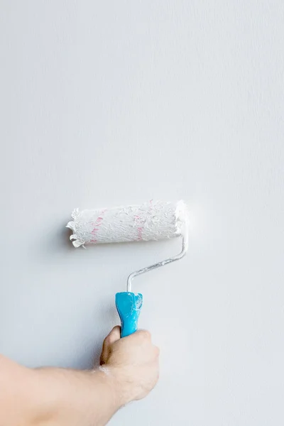 Woman hand holding a paint roller isolated on a white background — Stock Photo, Image