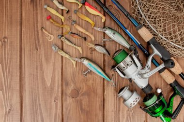 Kyiv, Ukraine - February 22, 2019: Fishing tackle - fishing spinning, hooks and lures on wooden background with copy space