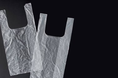 Siyah bir arka planda kolları, eldiven, plastik torba. İkinci el p