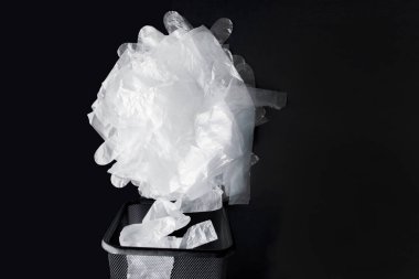 Kolları ile plastik torba, siyah bir arka planda bin eldiven. Geri dönüşüm için kullanılmış plastik torba. Konsept-ekoloji, plastik sellophane polietilen ile gezegen kirliliği