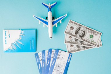 Passport, dollars, plane and air ticket on a blue background. Tr clipart