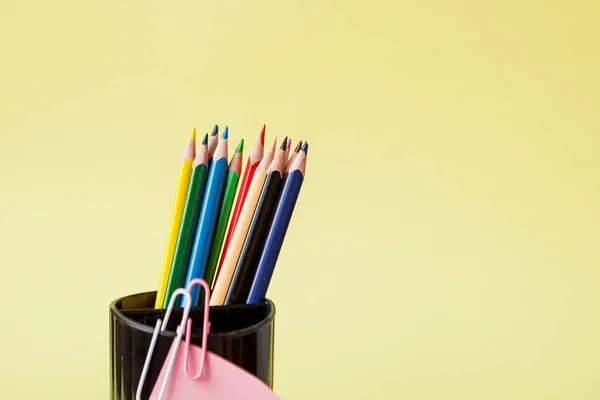 Fila de lápices de colores sobre fondo amarillo — Foto de Stock