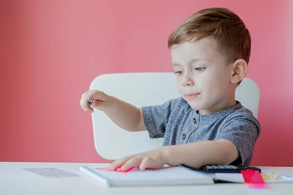 Ev ödevi yapma evde sevimli çocuk çocuk portresi. Küçük konsantre çocuk renkli kalem ile yazma, kapalı. İlkokulda ve eğitim. Çocuk yazma mektupları ve sayılar öğrenme — Stok fotoğraf