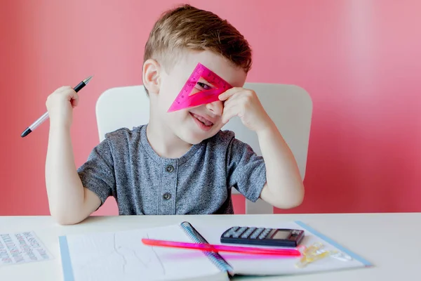 可爱的男孩在家里做家庭作业的肖像。小集中的孩子用五颜六色的铅笔在室内写作。小学和教育。孩子学习写信和数字 — 图库照片