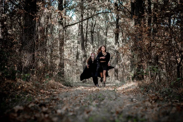 Halloween démon et sorcière courir à travers les bois — Photo