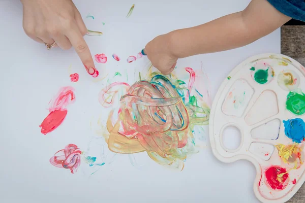 Mignon petit garçon peinture avec une peinture mains à l'aide de peintures gauche — Photo