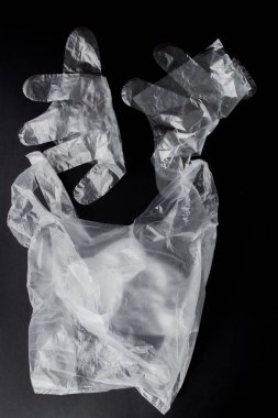 Siyah bir arka planda kolları, eldiven, plastik torba. İkinci el p