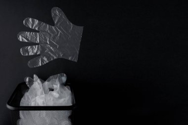 Kolları ile plastik torba, siyah bir artalan üzerinde bin eldiven