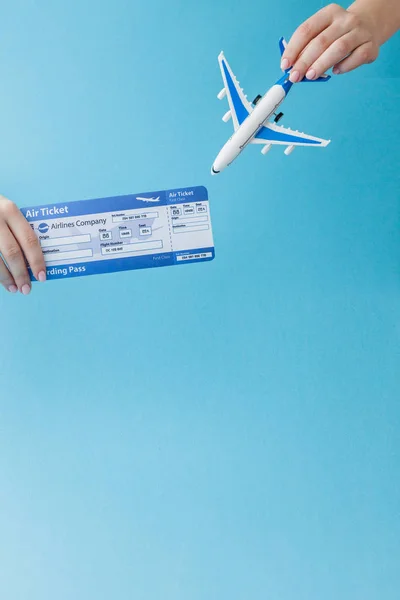 Vliegtuig en lucht ticket in Woman hand op een blauwe achtergrond. Reizen — Stockfoto