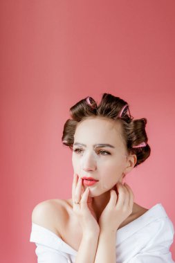 Yüzüne dokunmadan bir maske ve curlers ile güzel genç kız.