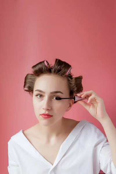 Agradável alegre jovem a menina no frisador pinta uma sobrancelha em — Fotografia de Stock