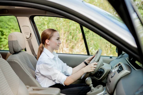 Ritratto ravvicinato di donna dall'aspetto piacevole con felice espressione positiva, soddisfatta di un viaggio indimenticabile in auto, si siede sul sedile del conducente. Persone, guida, trasporto concetto — Foto Stock