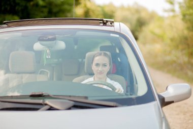 Arabadaki güzel kadının ön camından çekilen portre.