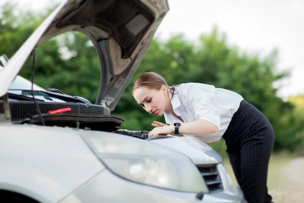Young woman by the roadside after her car has broken down She opened the hood to see the damage — Stock Photo, Image