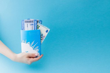 Mavi arka planda kadın el pasaport, Euro ve hava bileti