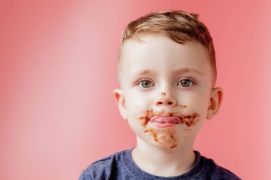 Küçük çocuk çikolata yiyor. Sevimli mutlu çocuk bulaşmış ile Chocola