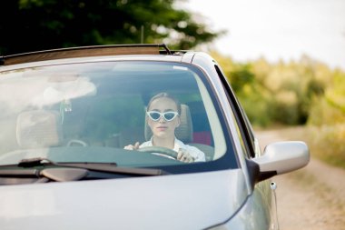 Arabadaki güzel kadının ön camından çekilen portre.